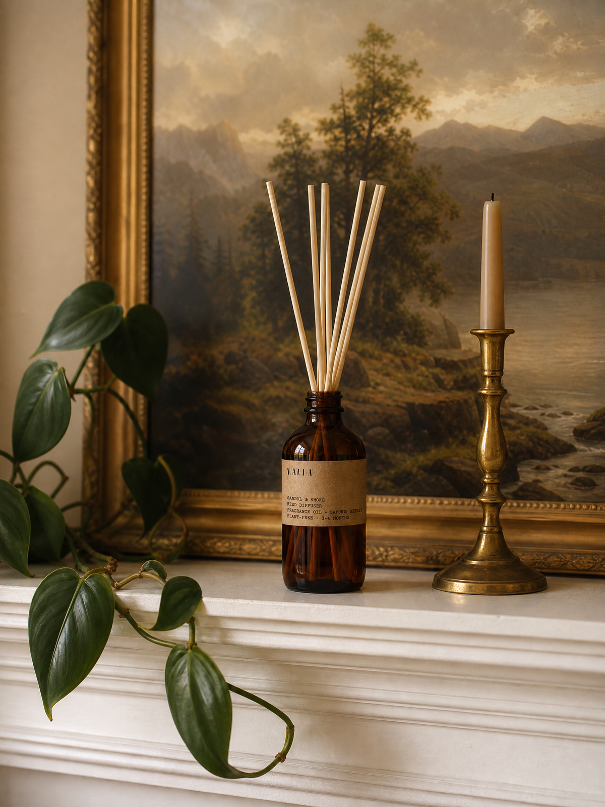 A reed diffuser on a mantelpiece beside a brass candlestick